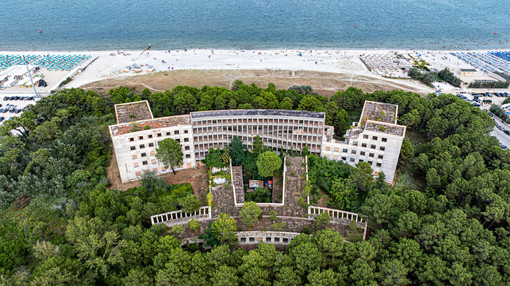 L'impressionante gigante addormentato e ormai a pezzi della Colonia Varese di Milano Marittima visto dal drone e separato solo dai pini dalla folla agostana sulle spiagge (foto Alessandro Umberto Galbiati)