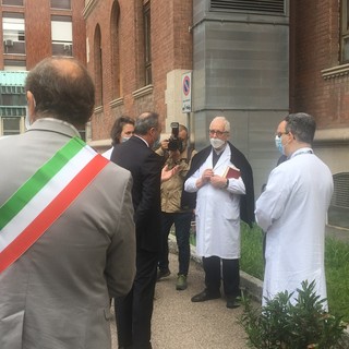 Don Peppino Colombo durante una visita dell'allora assessore regionale Gallera in ospedale