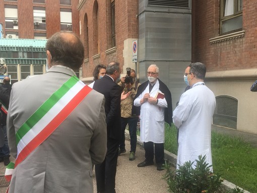 Don Peppino Colombo durante una visita dell'allora assessore regionale Gallera in ospedale